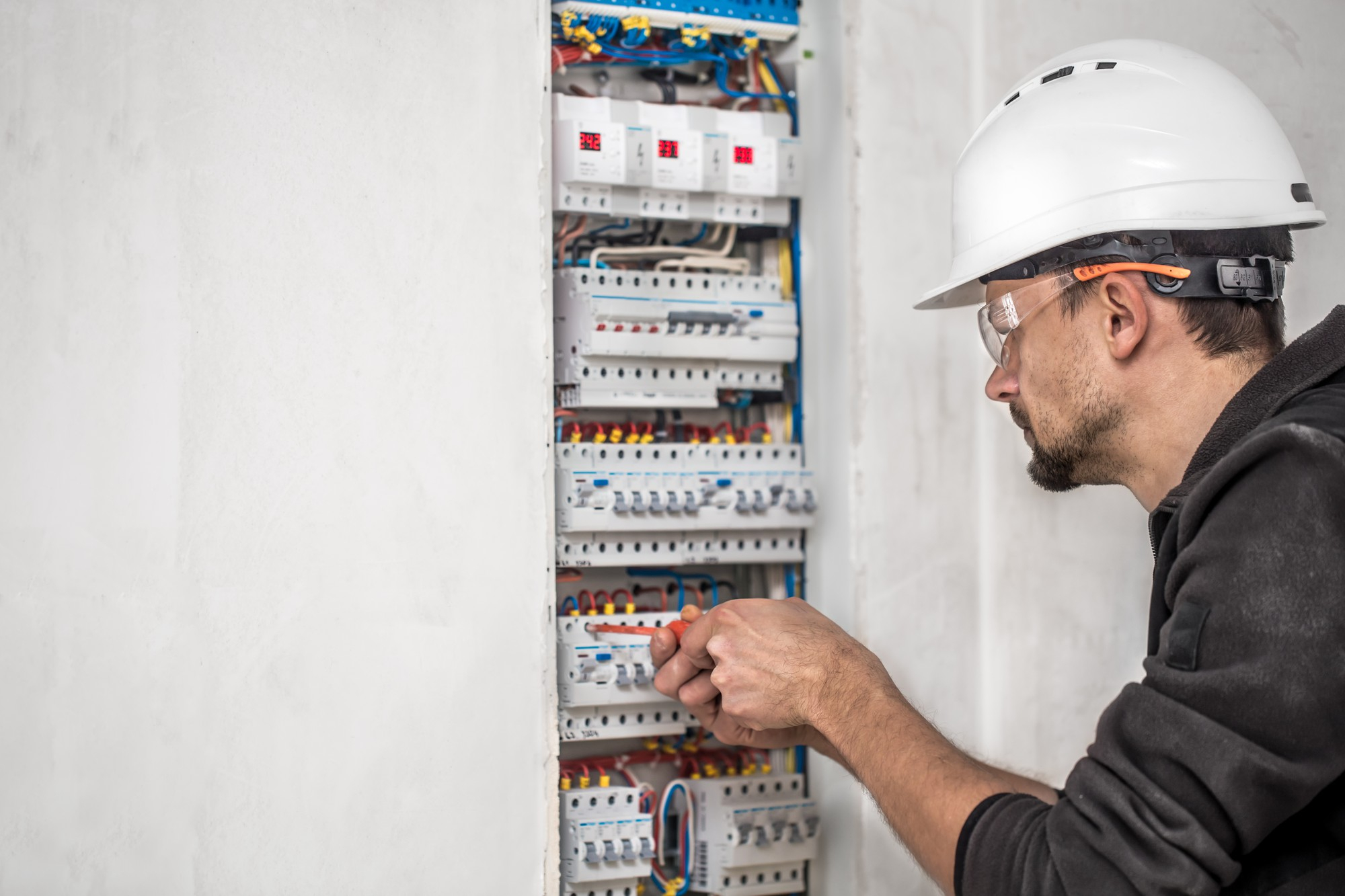 Électricien intervenant sur un tableau pour une mise aux normes électriques