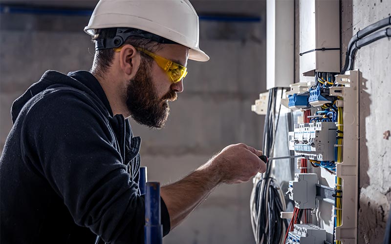 Électricien réalisant une rénovation et un dépannage électrique sur tableau