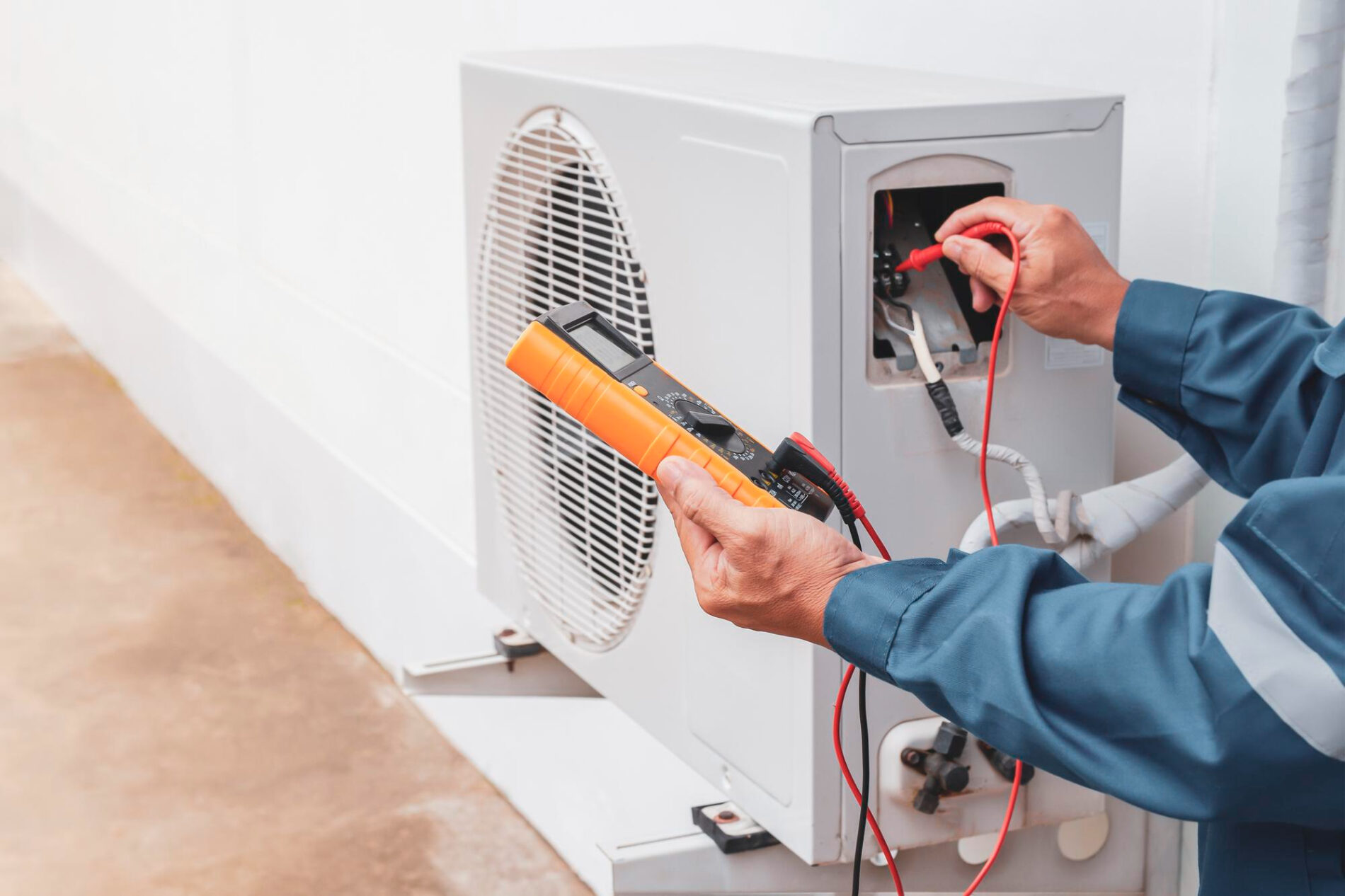 Technicien contrôlant une unité extérieure de climatisation et VMC