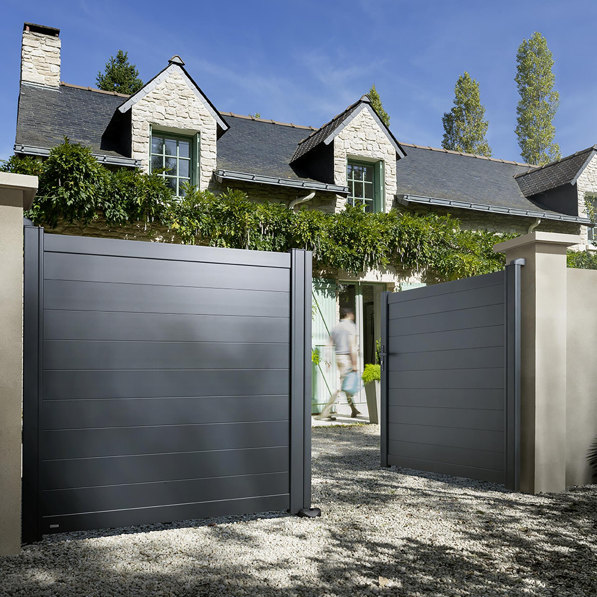 Portail motorisé installé devant une maison avec ouverture automatisée